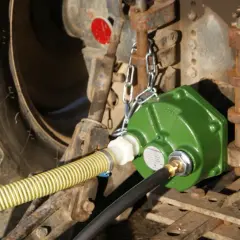 Grüne Zapfwellenpumpe mit Schläuchen an einem Traktor.