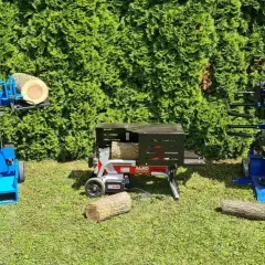 Zwei Holzspalter, einer mit Zapfwelle und ein elektrischer, stehen bereit, um Holz zu spalten.