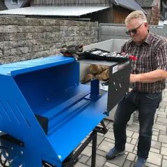 Mann mit Holzspalter Güde GHS 370/4TE, bereit, Holz zu spalten.