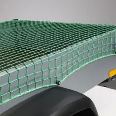 Grünes Abdecknetz sichert die Ladung auf einem Anhänger. Perfekt für den Transport von Gartenabfällen oder sperrigen Gegenständen.