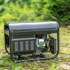 Schwarzes Akku-Aggregat steht im Gras, bereit für den Einsatz im Freien.