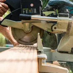 Präzise Schnitte mit der mobilen Kreissäge. Sägespäne fliegen, während Holz bearbeitet wird.