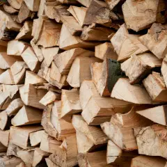 Ein Stapel gespaltenes Holz, bereit zum Bongossi Holz verbrennen. Die Maserung und die Rinde sind gut sichtbar.