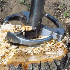 Eine starke Maschine zerkleinert einen Baumstumpf zu Spänen. Das Entfernen von Baumstümpfen wird so zum Kinderspiel.