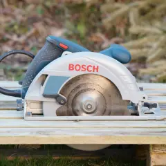 Bosch Kreissäge bereit für den Einsatz. Sie liegt auf Holzplanken, ideal zum Zerkleinern von Brennholz.