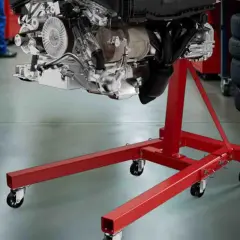 Ein Motor hängt an einem roten hydraulischen Getriebeheber.