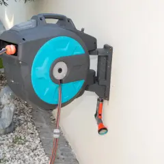 Ein schwarzer wandschlauchaufroller mit türkisfarbenen Akzenten hängt an einer weißen Wand. Ein Gartenschlauch ist teilweise aufgerollt.