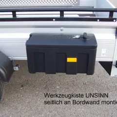 Schwarze Werkzeugbox seitlich am Anhänger montiert, mit Schlüssel.