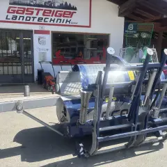 Blauer Holzspalter Tajfun RCA 400 gebraucht vor einem Landtechnikgeschäft.