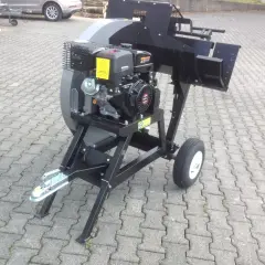 Robuste wippsäge mit benzinmotor, bereit für den Einsatz im Garten oder Wald. Mit Anhängerkupplung und Rädern für einfachen Transport.