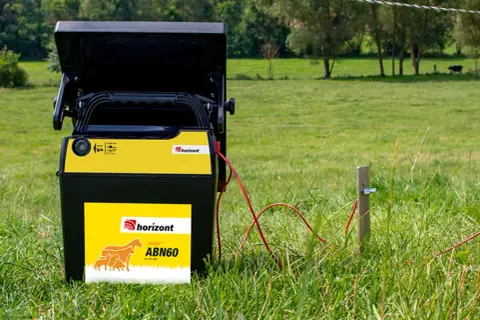 Ein Horizont Weidezaungerät steht im Gras, bereit, die Tiere auf der saftigen Weide sicher zu halten.