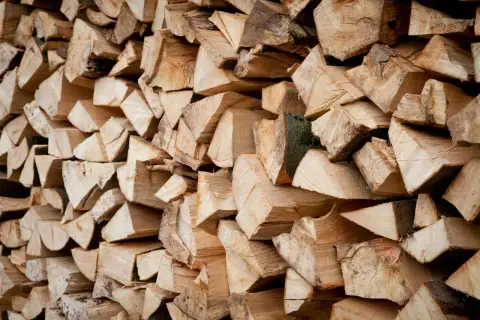 Ein Stapel gespaltenes Holz, bereit zum Bongossi Holz verbrennen. Die Maserung und die Rinde sind gut sichtbar.