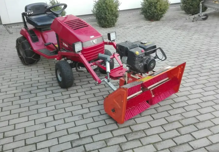Selbstgebaute Kehrmaschine mit Toro-Aufsitzmäher, Motor und breiter Bürste. Perfekt für den Winterdienst!