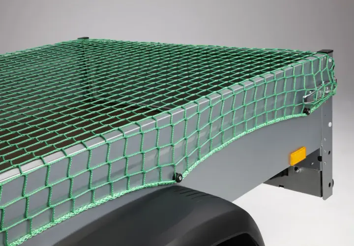 Grünes Abdecknetz sichert die Ladung auf einem Anhänger. Perfekt für den Transport von Gartenabfällen oder sperrigen Gegenständen.