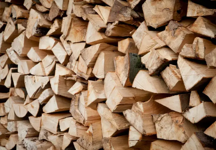 Ein Stapel gespaltenes Holz, bereit zum Bongossi Holz verbrennen. Die Maserung und die Rinde sind gut sichtbar.