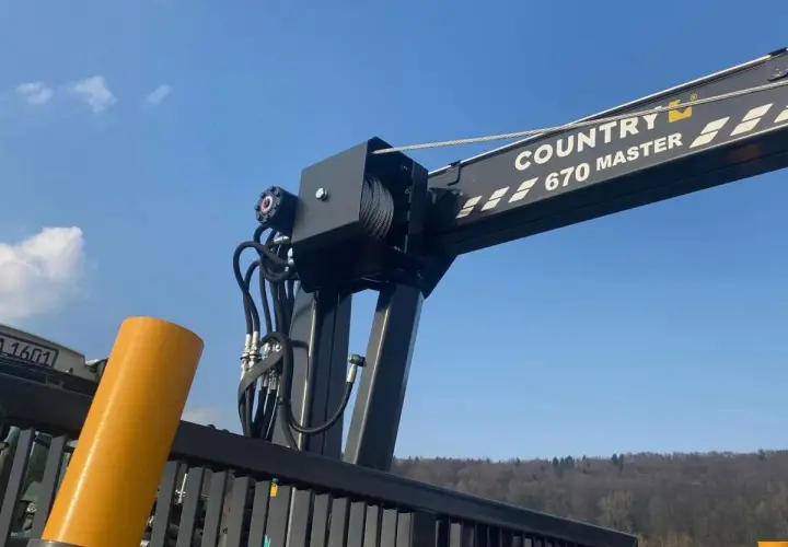 Ein Kranarm mit der Aufschrift "COUNTRY 670 MASTER" und Seilwinden, bereit für den Einsatz. Die robusten Seile erinnern an starke **Chokerketten**.