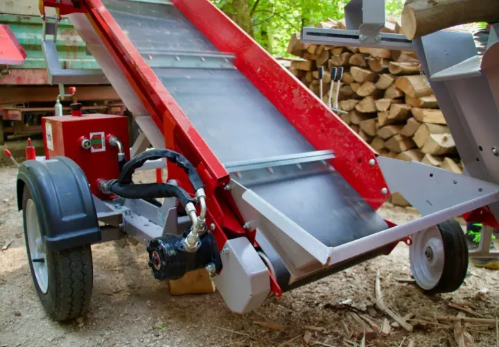 Rotes, teleskopierbares Förderband für Holzspalter, mit Rädern und Hydraulik.
