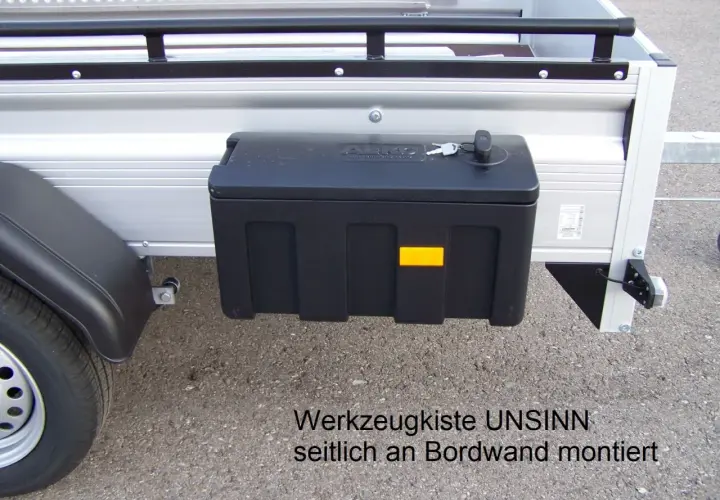 Schwarze Werkzeugbox seitlich am Anhänger montiert, mit Schlüssel.