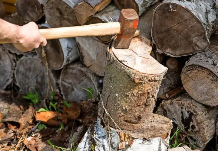 Mann spaltet Holz mit Axt. Der Stapel zeigt, wie man Holz stapeln kann, mit Rinde nach oben oder unten.