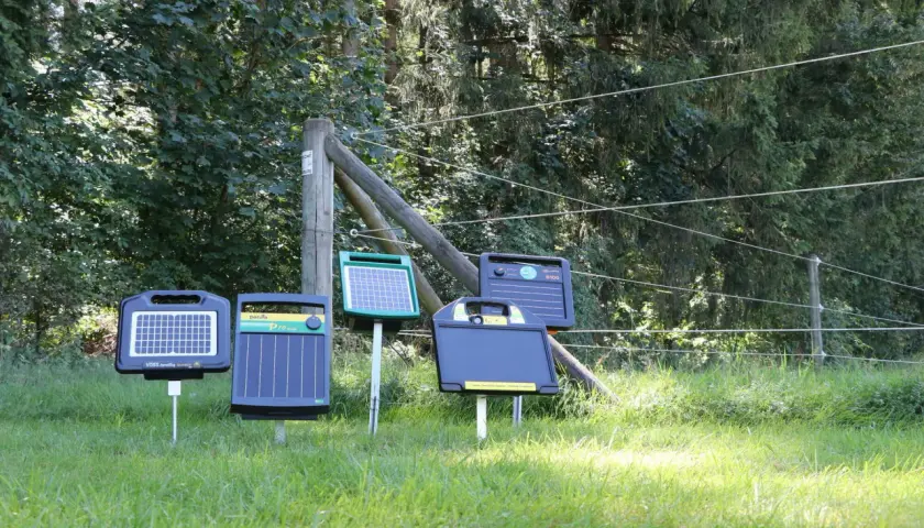 Mehrere solar stromgeräte stehen auf einer sonnigen Wiese, bereit, Tiere sicher einzuzäunen.