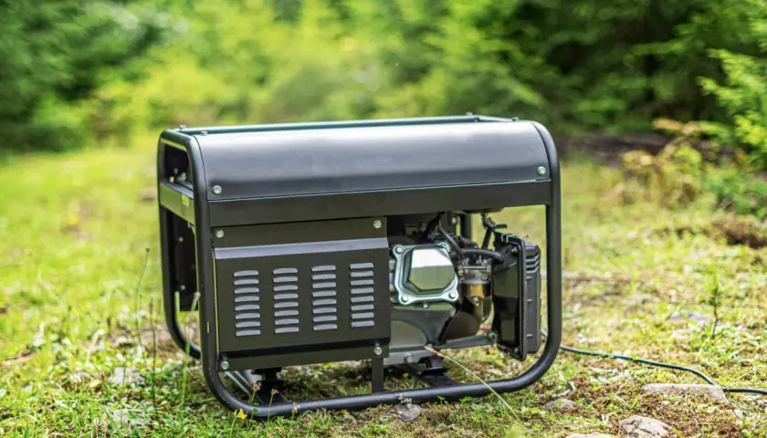 Schwarzes Akku-Aggregat steht im Gras, bereit für den Einsatz im Freien.