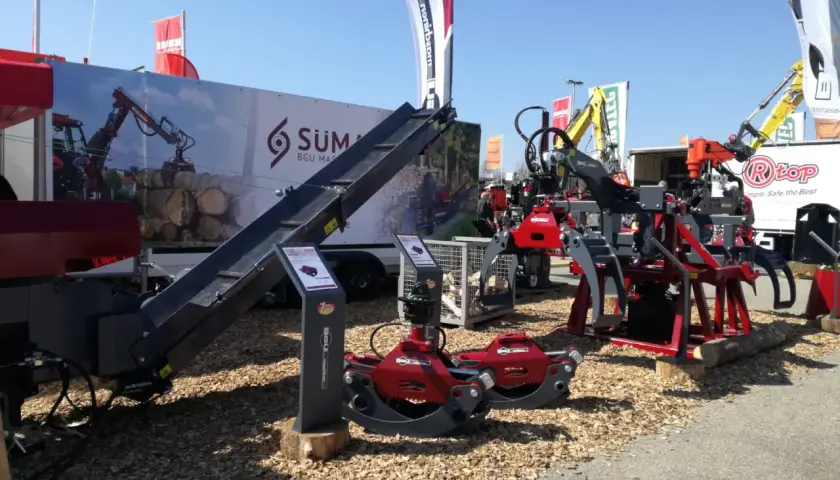 Holzspaltmaschinen und Kräne von SÜMA BGU Maschinen auf einer Messe.