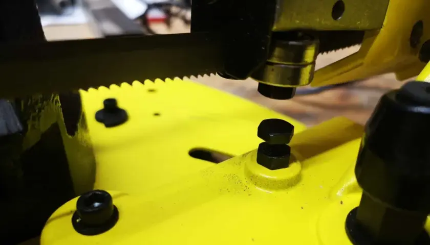 Nahaufnahme einer gelben Stahlwerk Bandsäge mit scharfem Sägeblatt und Schrauben.