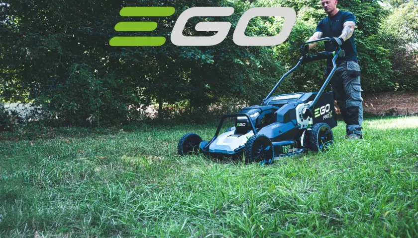 Mann schiebt einen EGO Rasenmäher durch grünes Gras.