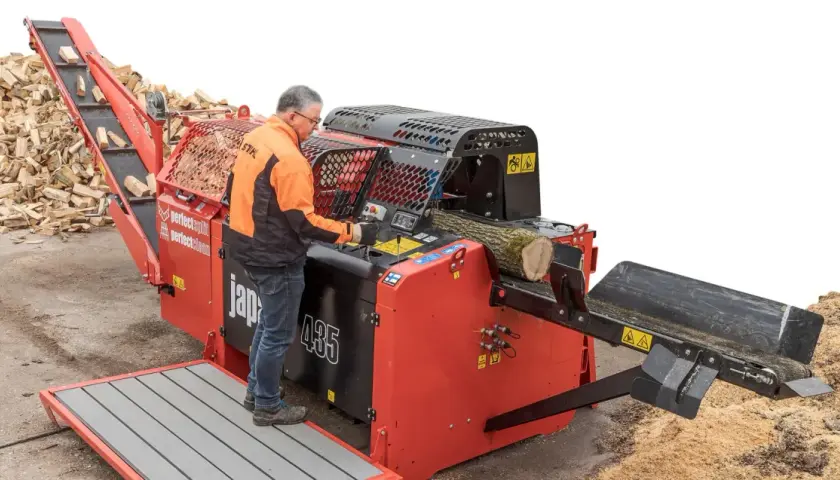 Mann bedient einen BGU Sägespaltautomat, der Holzscheite effizient verarbeitet.