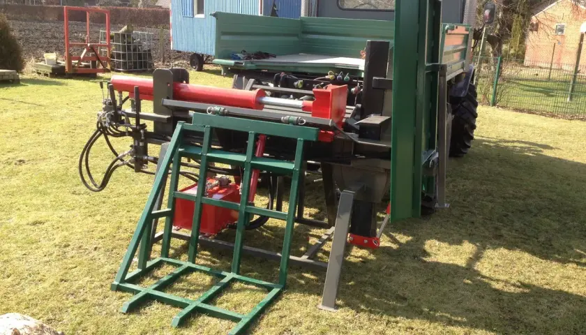 Selbstgebauter Holzspalter mit rotem Zylinder und grüner Aufnahme, bereit für den Einsatz. Ein Projekt, um Holzspalter manuell selber bauen.
