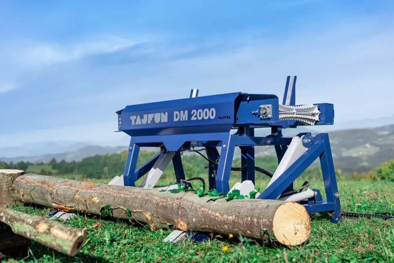 Der Tajfun DM 2000, ein Holzspalter, steht bereit, um Baumstämme im Freien zu bearbeiten.