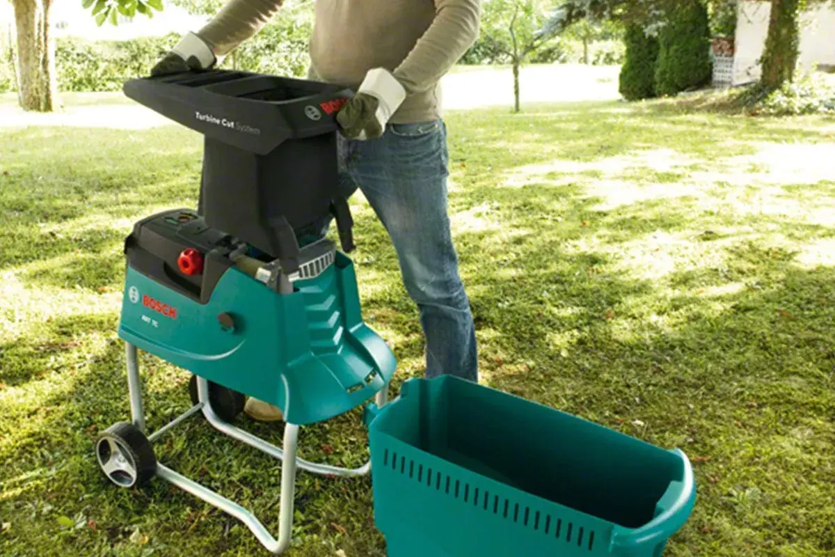 Gartenarbeit leicht gemacht: Ein Mann bedient einen Bosch Häcksler, den meister shredder, im Garten.