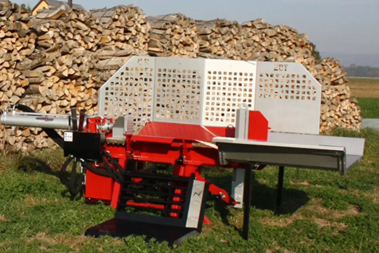 Roter Holzspalter mit silberner Verkleidung steht vor einem großen Holzstapel. Der Holzspalter fährt nicht hoch, was auf ein Problem hindeutet.