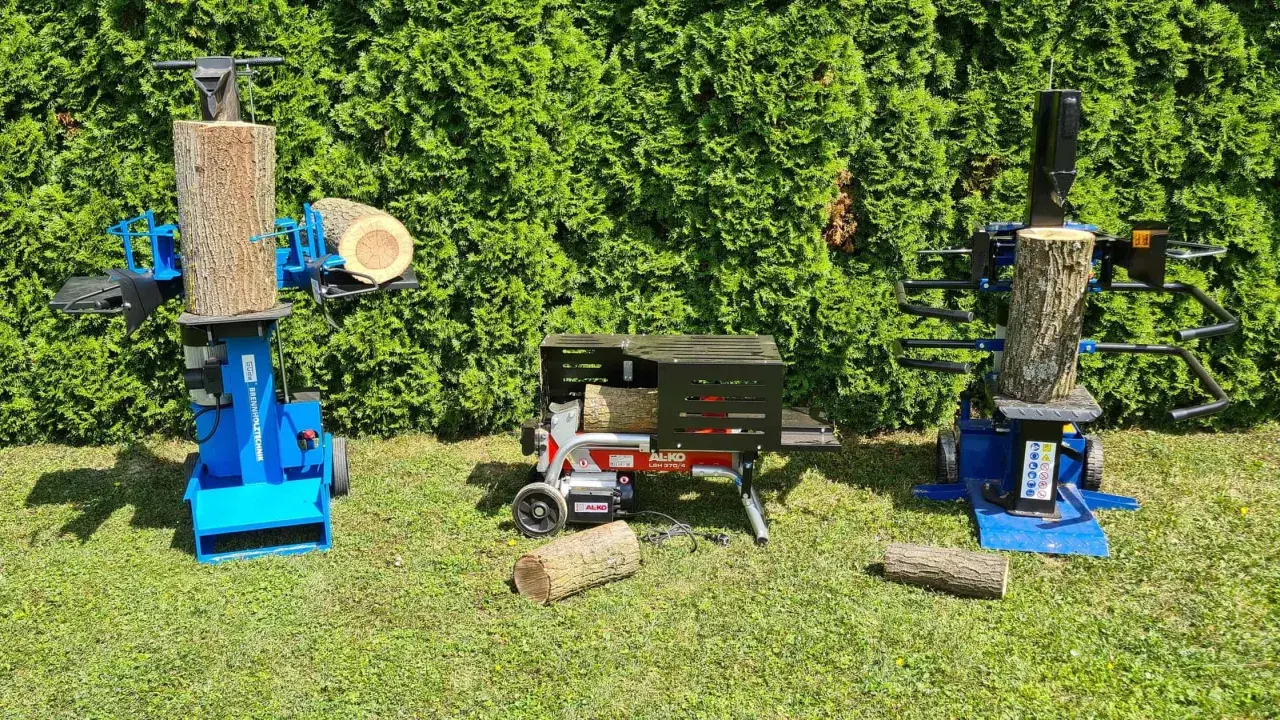 Zwei Holzspalter, einer mit Zapfwelle und ein elektrischer, stehen bereit, um Holz zu spalten.