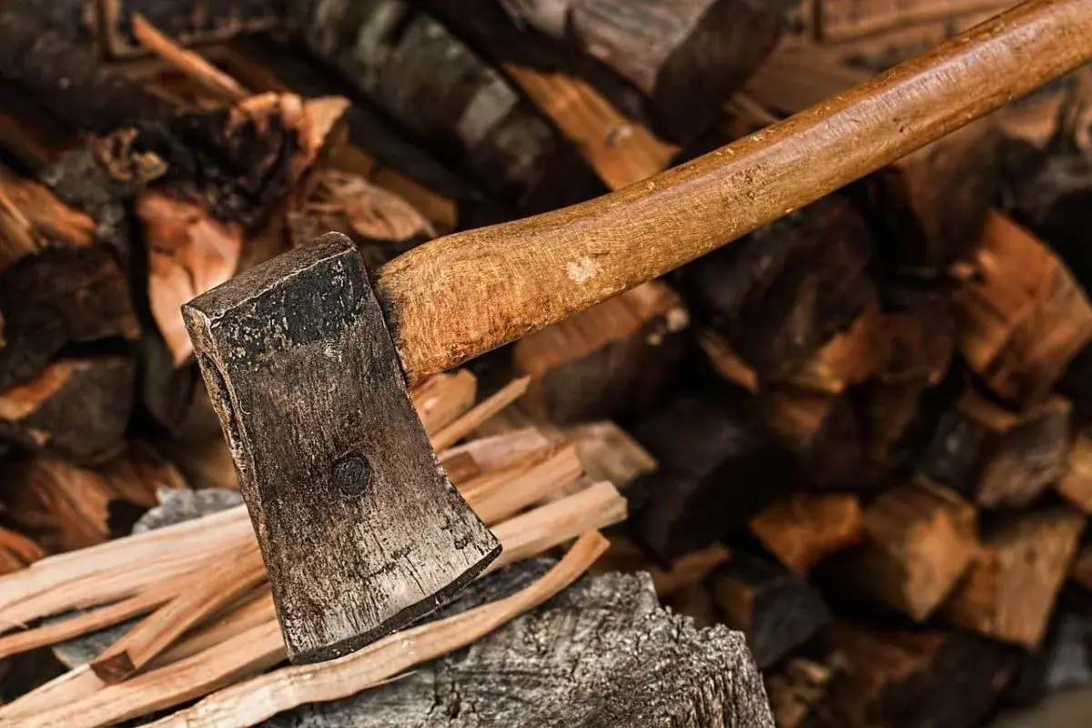 Axt liegt auf einem Stapel gespaltenen Holzes. Das Holz ist trocken und bereit, ein gutes Brennholz zu werden.