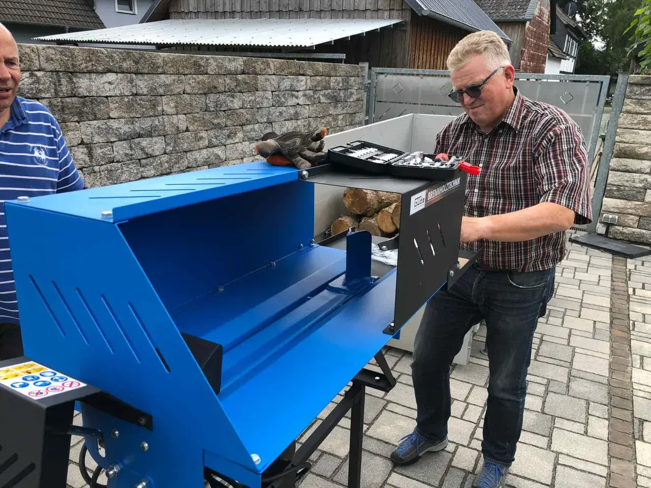 Mann mit Holzspalter Güde GHS 370/4TE, bereit, Holz zu spalten.
