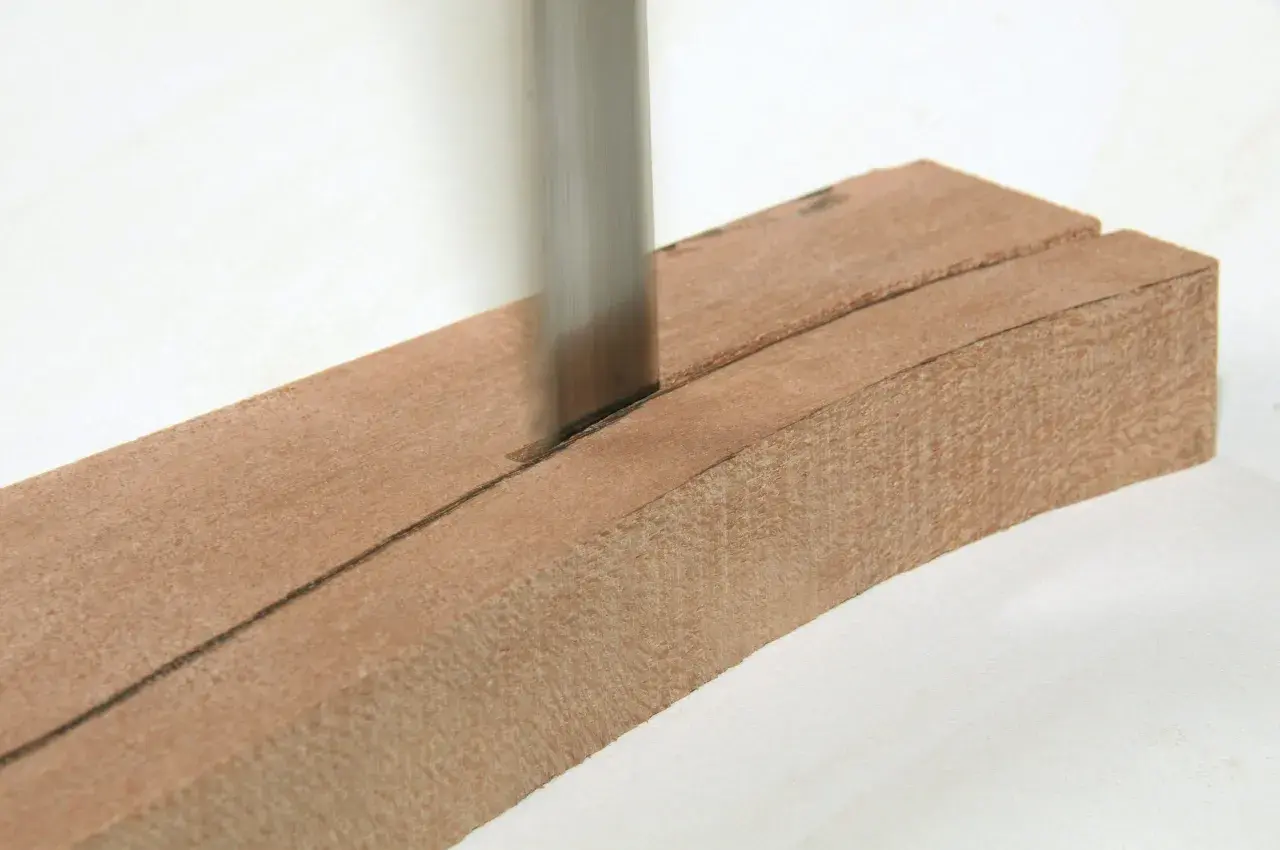 Ein scharfes Sägeblatt schneidet präzise durch ein Holzstück, das für eine Scheifele Bandsäge vorbereitet wird.