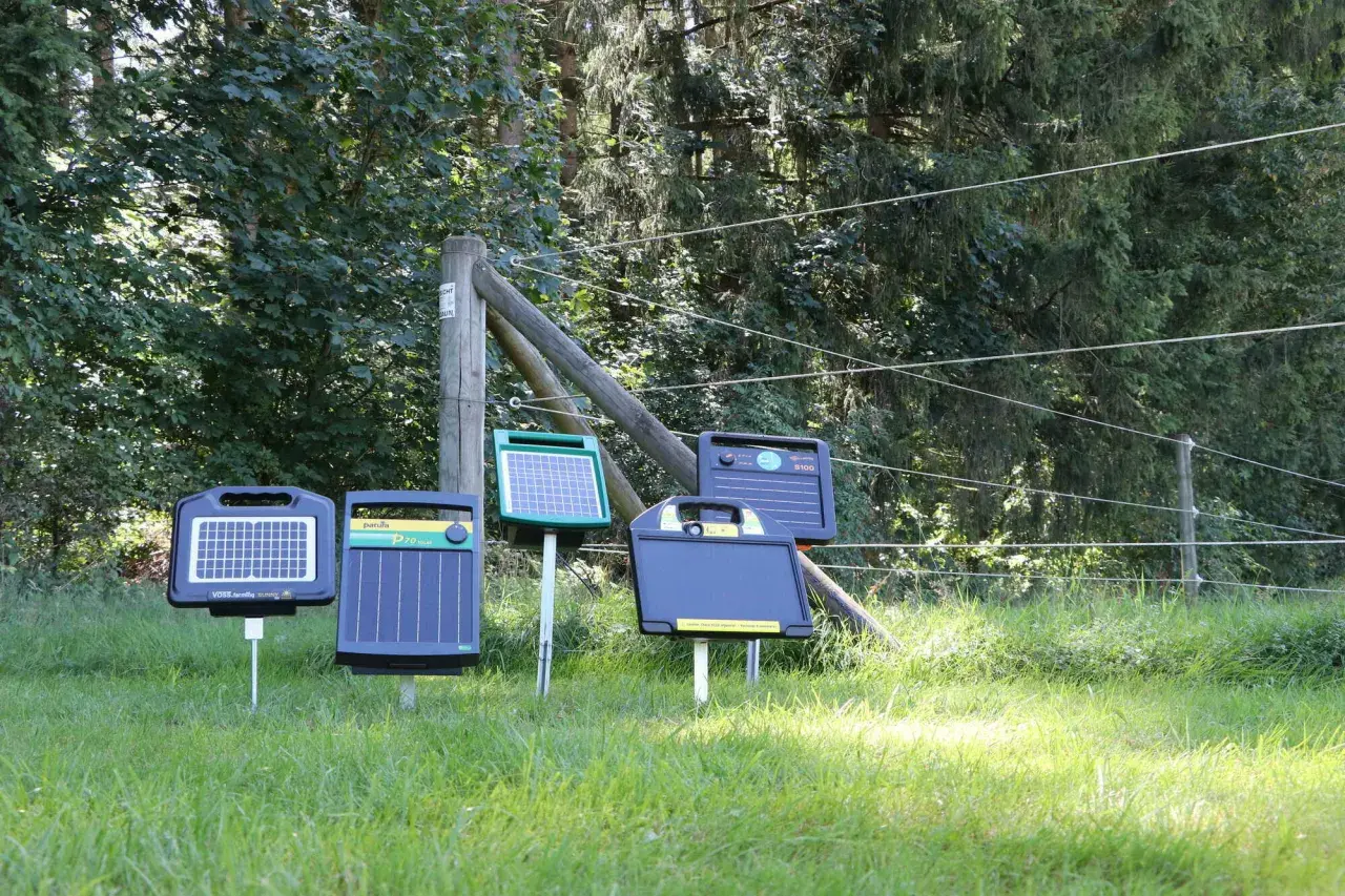 Mehrere solar stromgeräte stehen auf einer sonnigen Wiese, bereit, Tiere sicher einzuzäunen.