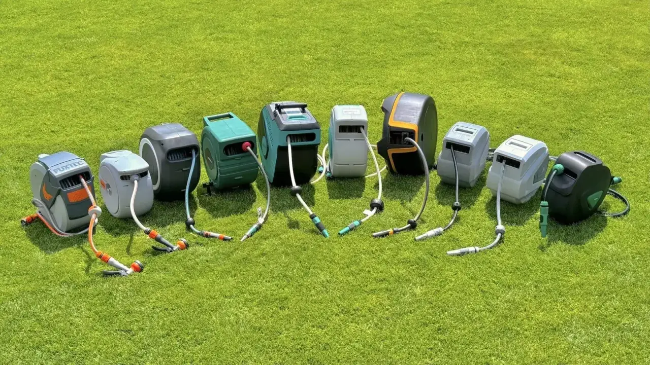Reihe von schlauchaufroller garten Modellen in verschiedenen Farben und Designs, auf grünem Rasen arrangiert.