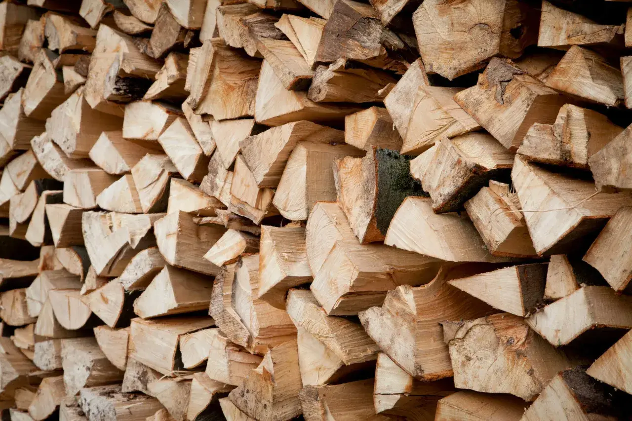 Ein Stapel gespaltenes Holz, bereit zum Bongossi Holz verbrennen. Die Maserung und die Rinde sind gut sichtbar.