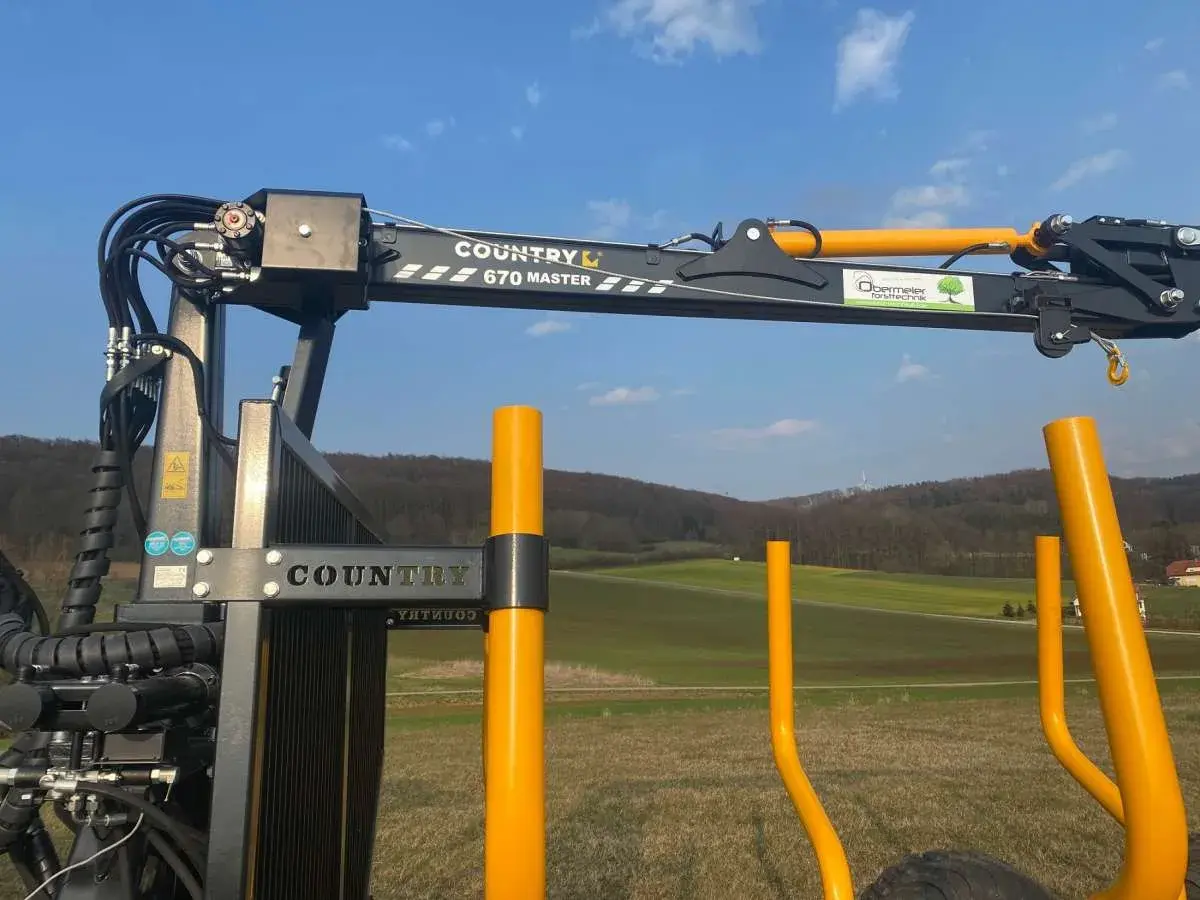 Ein COUNTRY 670 MASTER Kran mit Seilwinde und Funksteuerung steht bereit für den Holzeinsatz.