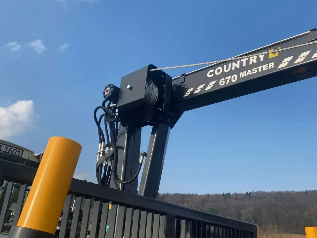 Ein Kranarm mit der Aufschrift "COUNTRY 670 MASTER" und Seilwinden, bereit für den Einsatz. Die robusten Seile erinnern an starke **Chokerketten**.