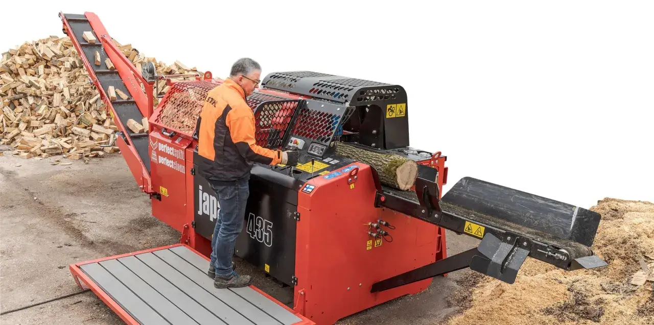 Mann bedient einen BGU Sägespaltautomat, der Holzscheite effizient verarbeitet.