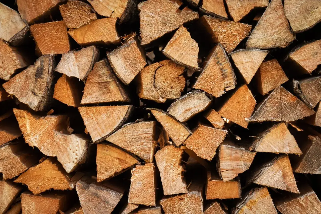 Stapel von gespaltenem Holz, bereit, das Feuer zu entfachen. Das Teakholz verbrennen wird wohlige W&auml;rme spenden.