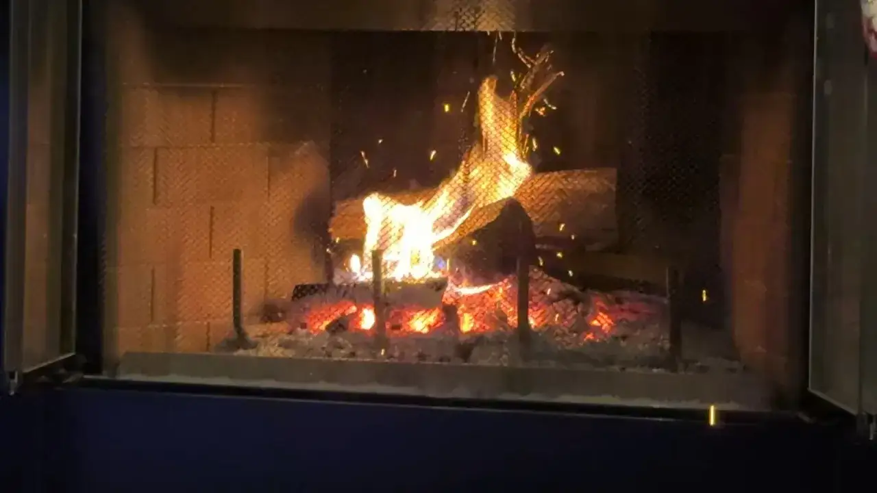 Gl&uuml;hendes Fichtenholz verbrennen im Kamin, Funken fliegen.