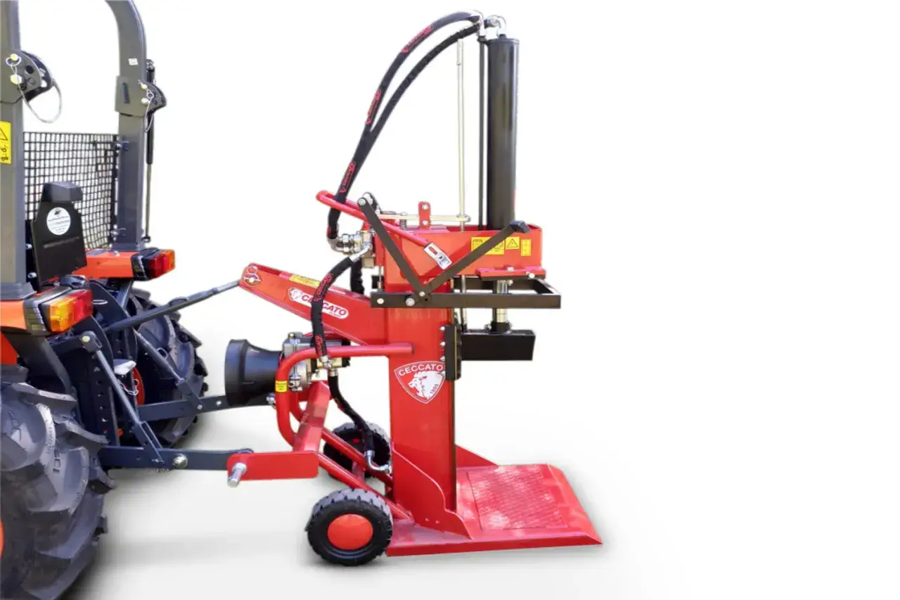Roter Holzspalter mit Zapfwelle, angetrieben von einem Traktor. Bereit für die Holzernte.