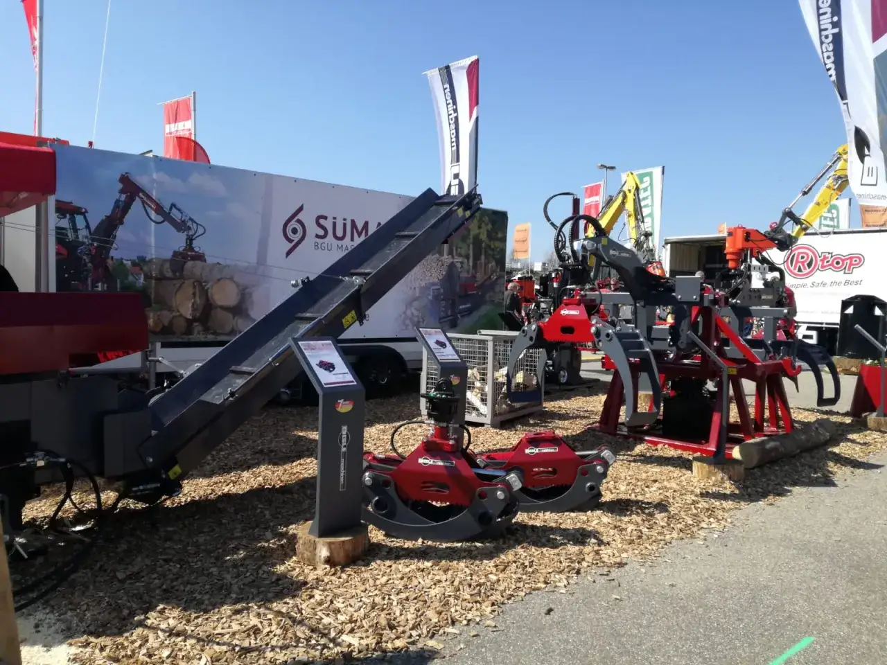 Holzspaltmaschinen und Kräne von SÜMA BGU Maschinen auf einer Messe.