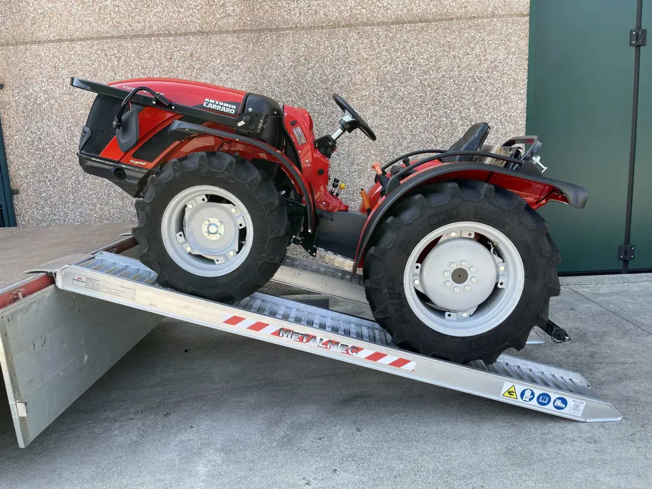 Roter Traktor fährt auf stabile Auffahrrampen 2t.