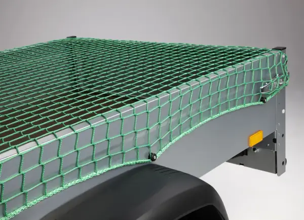 Grünes Abdecknetz sichert die Ladung auf einem Anhänger. Perfekt für den Transport von Gartenabfällen oder sperrigen Gegenständen.
