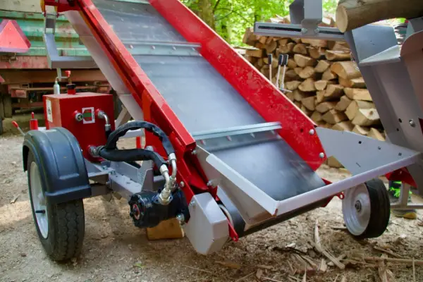 Rotes, teleskopierbares Förderband für Holzspalter, mit Rädern und Hydraulik.